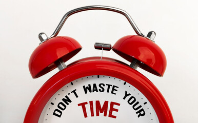 Red alarm clock with text DON'T WASTE YOUR TIME