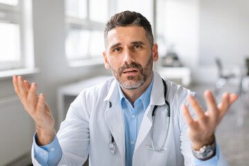 Consultation with doctor. Male doctor talking to camera, gesturing, physician explaining treatment...