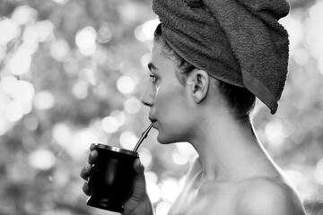 woman having breakfast grass mat in hand after morning shower and towel on head enjoying nature...