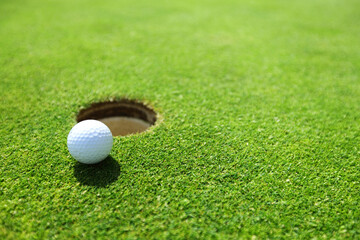 golf ball on lip of cup - 595536040