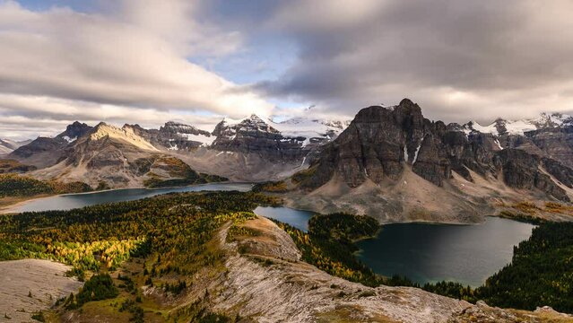 Beautiful view of Nublet Peak with Mount Assiniboine and lake in autumn forest on cloudy day at provincial park