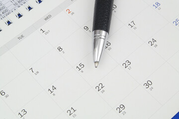 Calendar page with black pen, top view. Business time concept.