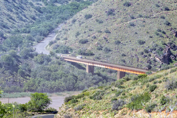 Vehicle is visible on bridge through spray of the Gariep Dam