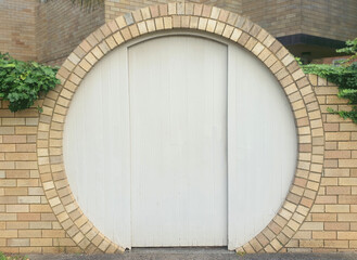 white timber door on round frame brick wall