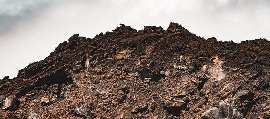 Magmatic soil and volcanic rocks. Irregularity of the ground on the slopes of a large volcano. Craters, furrows, holes and large dark rocks. Valleys of eruptive origin, desertification and drought.