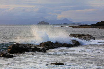 Crashing waves at Duntulm Beach Isle of Skye with the outer Hebrides in the distance. Scotland, UK.