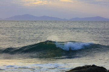 Crashing waves at Duntulm Beach Isle of Skye with the outer Hebrides in the distance. Scotland, UK.
