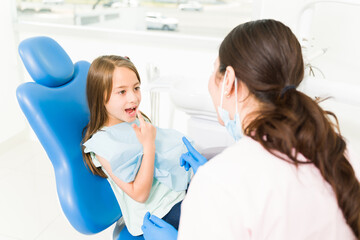 Fototapeta na wymiar Cheerful kid patient talking to the pediatric dentist