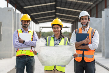 Group Indian construction team engineer wear vest and helmet safety and female leader hold...