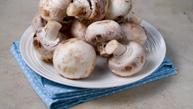 Raw champignon mushrooms on spinning plate. Fresh vegetables for cooking.