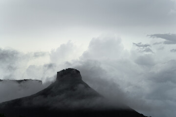 Mysterious Pyramidal Mountain Silhouette with Fog and Clouds