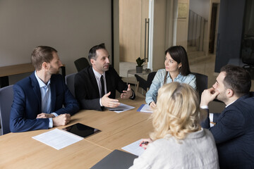 Confident mature business leader man speaking to colleagues on corporate meeting, explaining idea,...