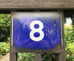 Blue metal number plate with the number 8