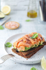 A rye bread sandwich with avocado and salmon