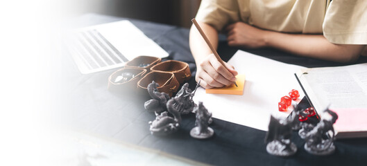 Woman hand writing for create story setup adventure role playing tabletop and board games hobby...