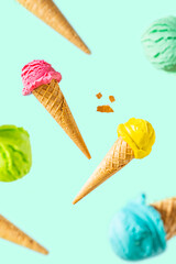 Flying colorful ice cream scoops in cones, bright background. Levitation