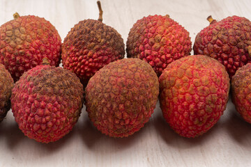 Fresh lychee with leaves isolated on wooden background.