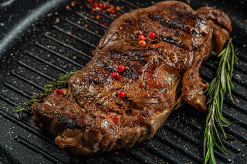 grilled marbled beef steak striploin with spices in a grill pan. place for text, top view
