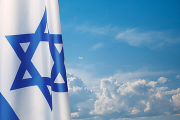 Israel flag with a star of David over cloudy sky background. Banner with place for text.