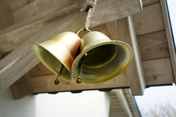 Gold decorative house bells. Golden bells hanging in front of house doors.