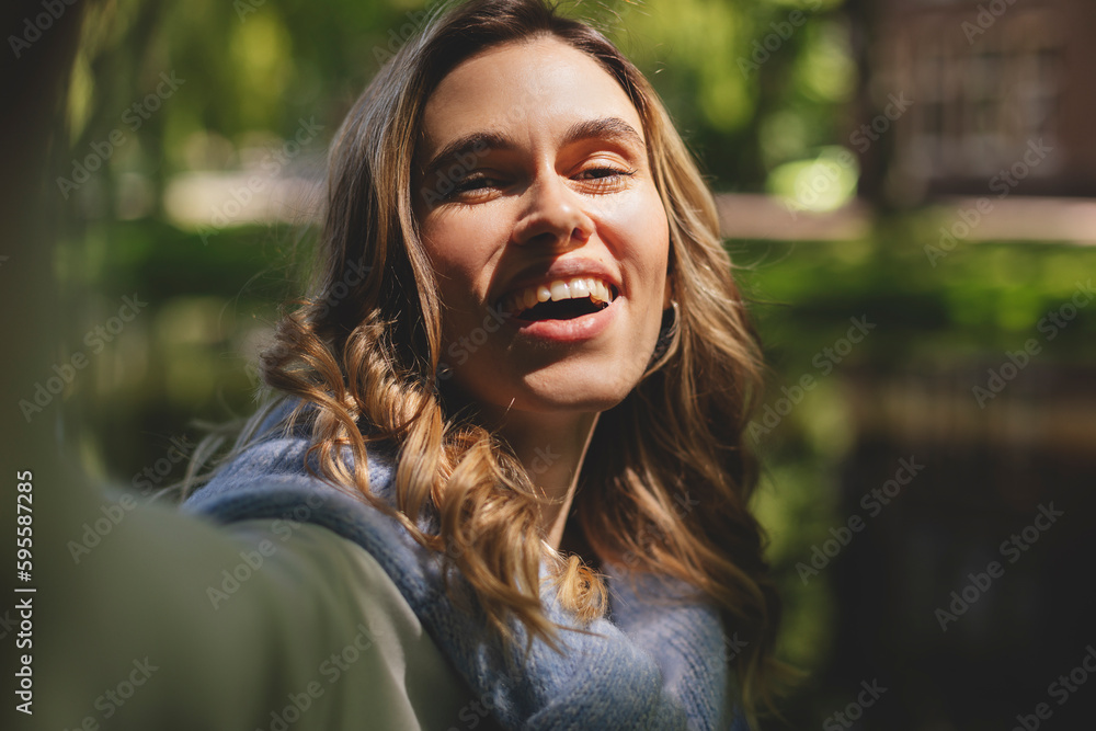 Wall mural Photo of nice pretty happy charming blonde curly woman summer enjoy good mood make selfie camera outdoors outside park.