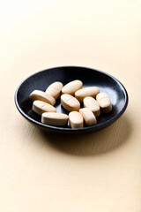 Vitamin C tablets on bright paper background. Soft focus. Close up. Copy space.