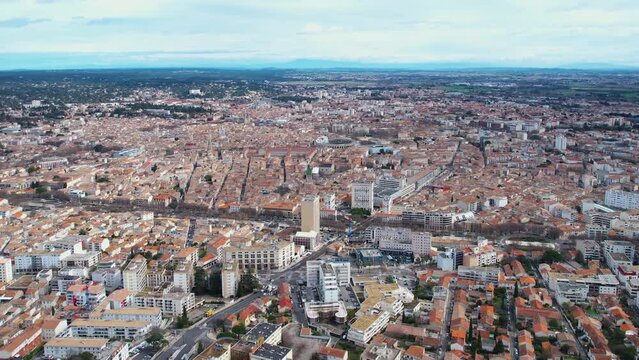 Aerial around the old town of Nîmes on a sunny day on a late afternoon in early spring.
