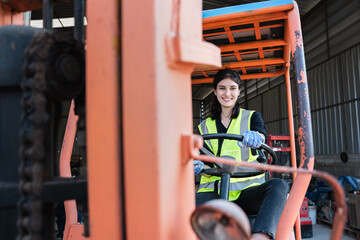 Fototapeta na wymiar Portrait of a woman working with a forklift in a warehouse. Concept industrial and commercial.