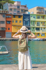 Fototapeta premium woman traveler visiting in Taiwan, Tourist with backpack and hat sightseeing in Keelung, Colorful Zhengbin Fishing Port, landmark and popular attractions near Taipei city . Asia Travel concept
