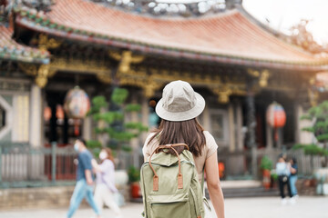 Fototapeta na wymiar woman traveler visiting in Taiwan, Tourist with hat sightseeing in Longshan Temple, Chinese folk religious temple in Wanhua District, Taipei City. landmark and popular. Travel and Vacation concept