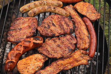 various meat and sausages on the charcoal grill