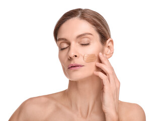 Woman with swatch of foundation on face against white background