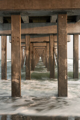 Repetition of the pilons, under a pier with long exposures in the evening.