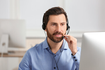Hotline operator with headset working in office