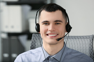 Hotline operator with headset working in office