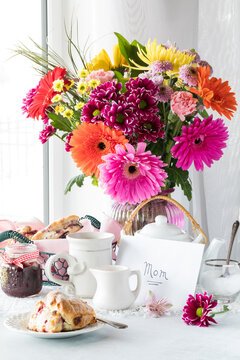 A beautiful Mother's Day flower arrangement with a card, tea and scones,