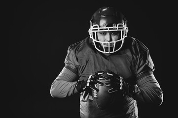 Portrait of a man in uniform for american football on a black background. Monochrome. 