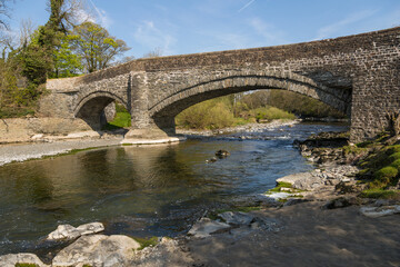 Fototapeta na wymiar A stone bridge over the Rawthey River in Sedbergh. Yorkshire, UK.