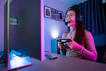 Asian modern female gamer having serious gaming fun in a RGB-lit gaming room. © SKW
