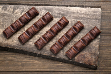 Tasty chocolate bars on wooden table, top view