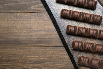 Tasty chocolate bars on wooden table, top view. Space for text