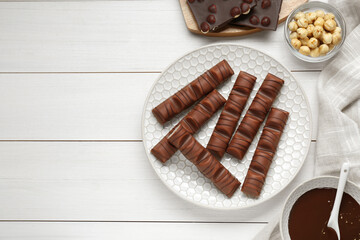 Tasty chocolate bars on white wooden table, flat lay. Space for text
