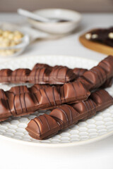 Tasty chocolate bars on white wooden table, closeup