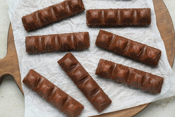 Sweet tasty chocolate bars on light table, top view