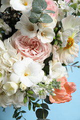 Obraz na płótnie Canvas Bouquet of beautiful flowers on light blue background, closeup