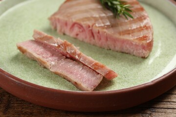 Delicious tuna steak on wooden table, closeup