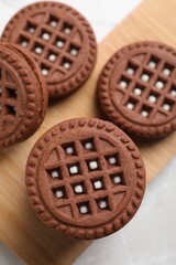Tasty chocolate sandwich cookies with cream on light table, flat lay