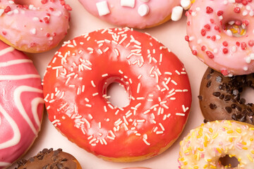 Donuts with red and pink glaze, top view. Lots of donuts, sweet and delicious food