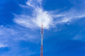 Telecommunication radio wave signal tower red and white with cloudy. Steel truss of transmission signal antenna with blue sky. Telecommunication tower, Global connection and internet network concept.