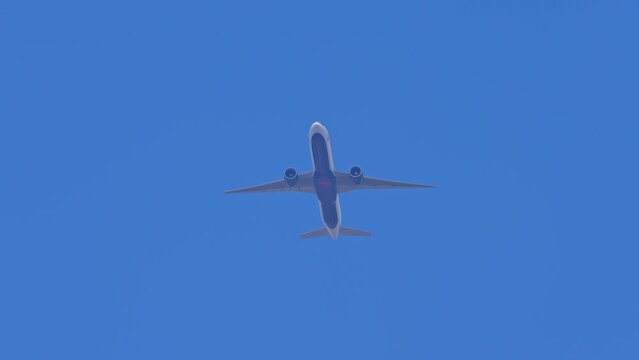 Airplane Air Canada passing overhead in the sky. Air passenger plane bottom view while flying. Jet aircraft departure climbs in the blue sky.